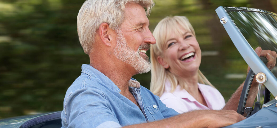 Mature,Couple,Enjoying,Road,Trip,In,Classic,Open,Top,Sports